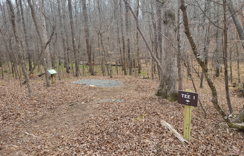 A small, brown sign points the way to the next hole.