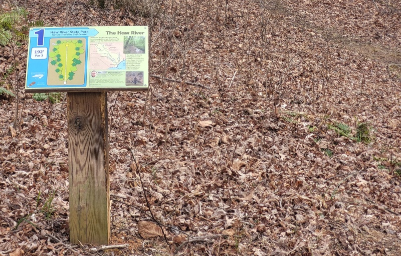 A small, interpretive tee sign on the disc golf course.
