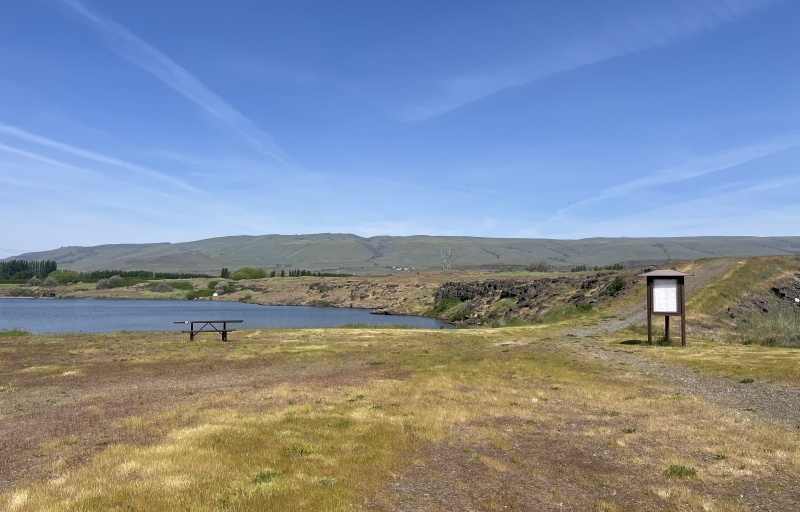 Landscape view of signage and the pond in the background