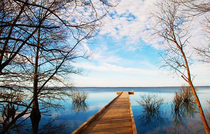 A picture of a dock stretching out across a blue water.