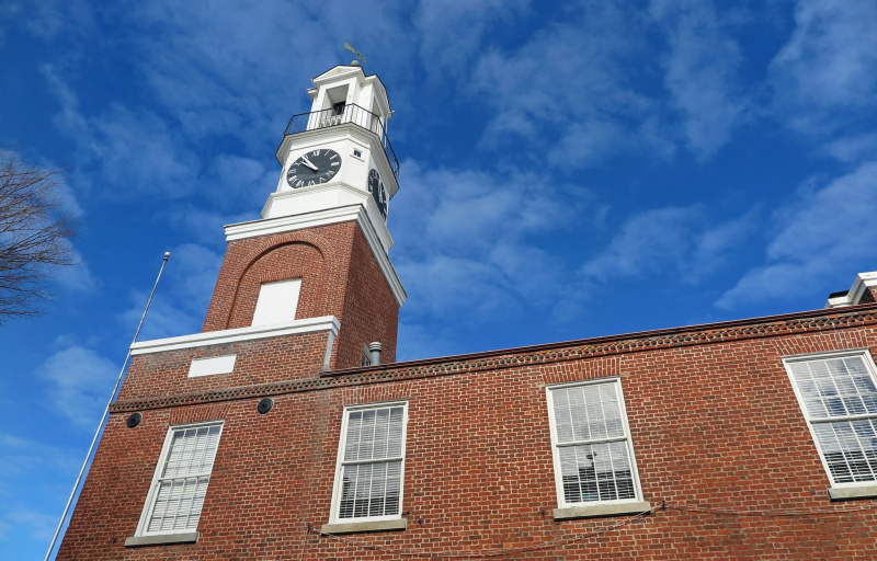 a view looking up at the town hall from the sidewalk