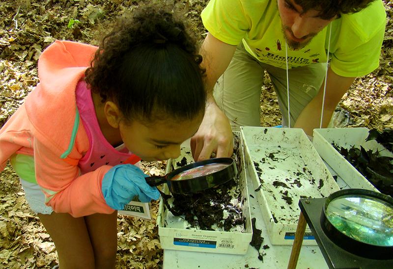 Girl with maginifying glass at Weir Farm National Historic Site. girl with magnifying glass