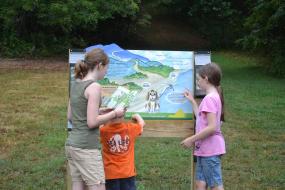 Kids standing by the Claytor lake TRACK Trail Sign