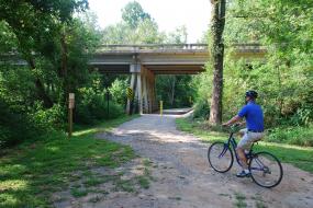 Biker on path leading under a roadway