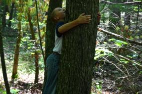 Young boy hugging tree on the Claytor lake TRACK Trail 