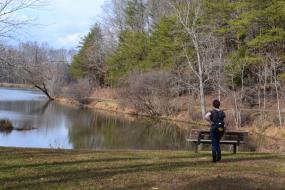 Disc golfer overlooking a lake 