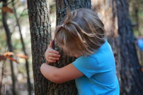 Young girl hugging a tree