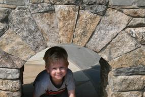 Young boy playing by Trail Head sign