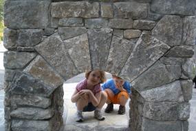 Young children playing by trail head sign