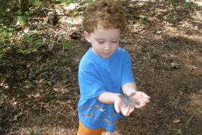 Young boy playing with feather on trail