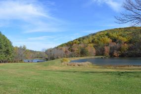 Two lakes in front of a wooded hill