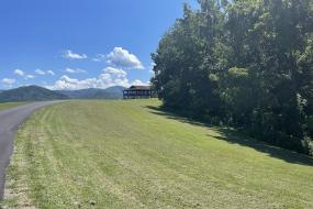 A view of an open pasture with the double pavilion in the background