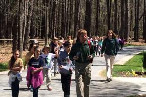 Group of kids hiking down a paved path