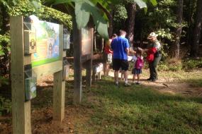 A family and the Kids in Parks trailhead sign
