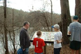 Family at interpretive sign along river