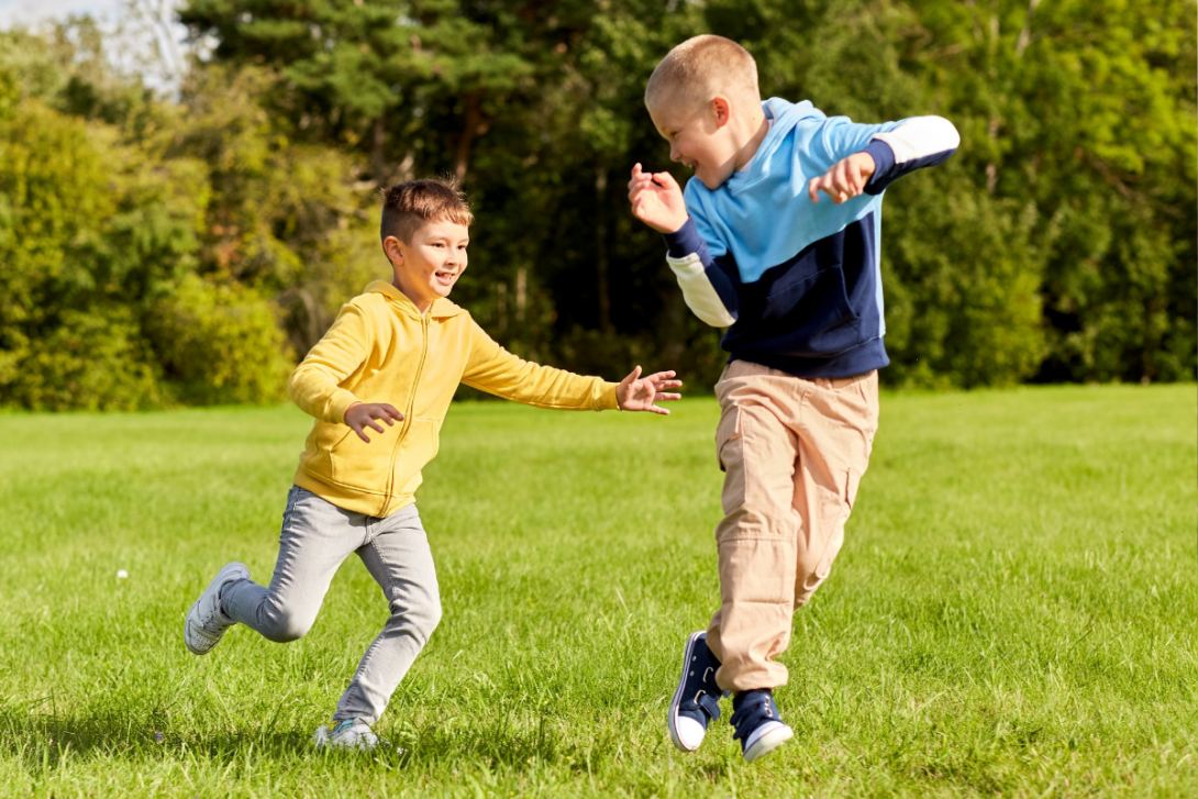 two kids playing tag in a field